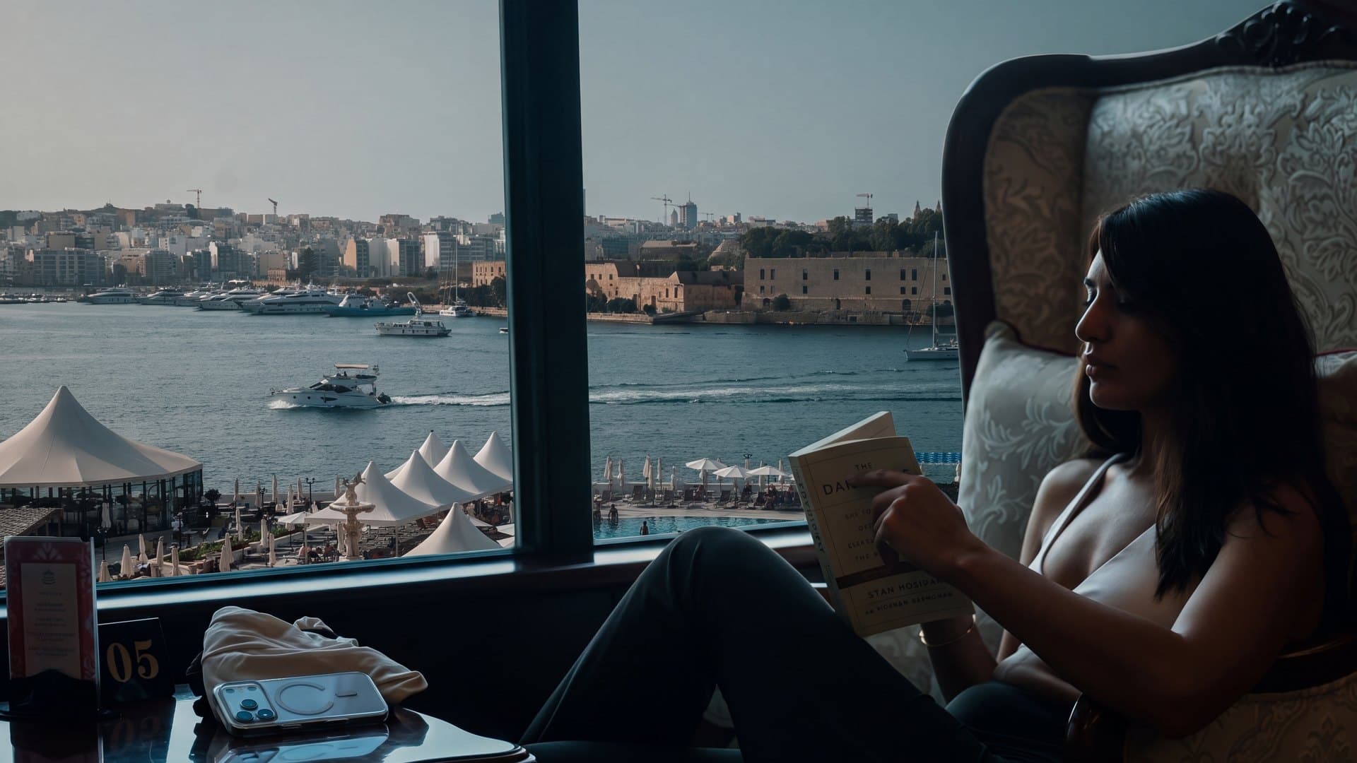 A member reading at The Admiral's Landing, the harbour beyond the window