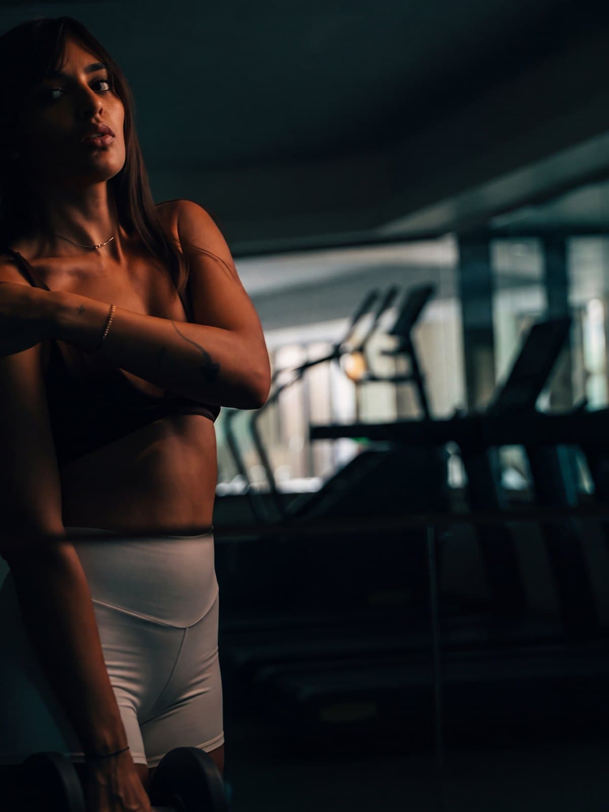 A member on the training floor, the cardio line behind her in shadow