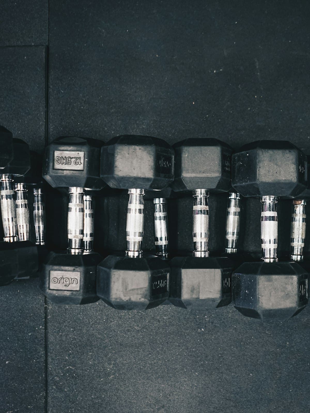 A rack of hex dumbbells in moody shadow