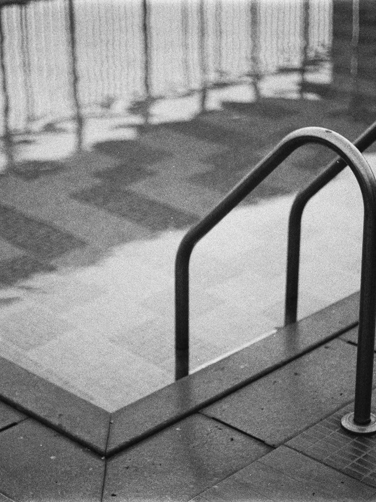 A still indoor pool edge in low-key monochrome