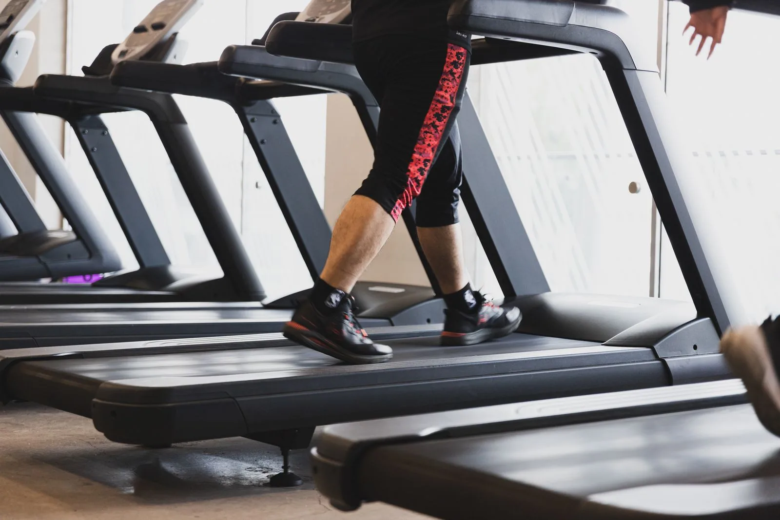 A person walking on a treadmill in a modern gym, building cardiovascular VO2 max reserve