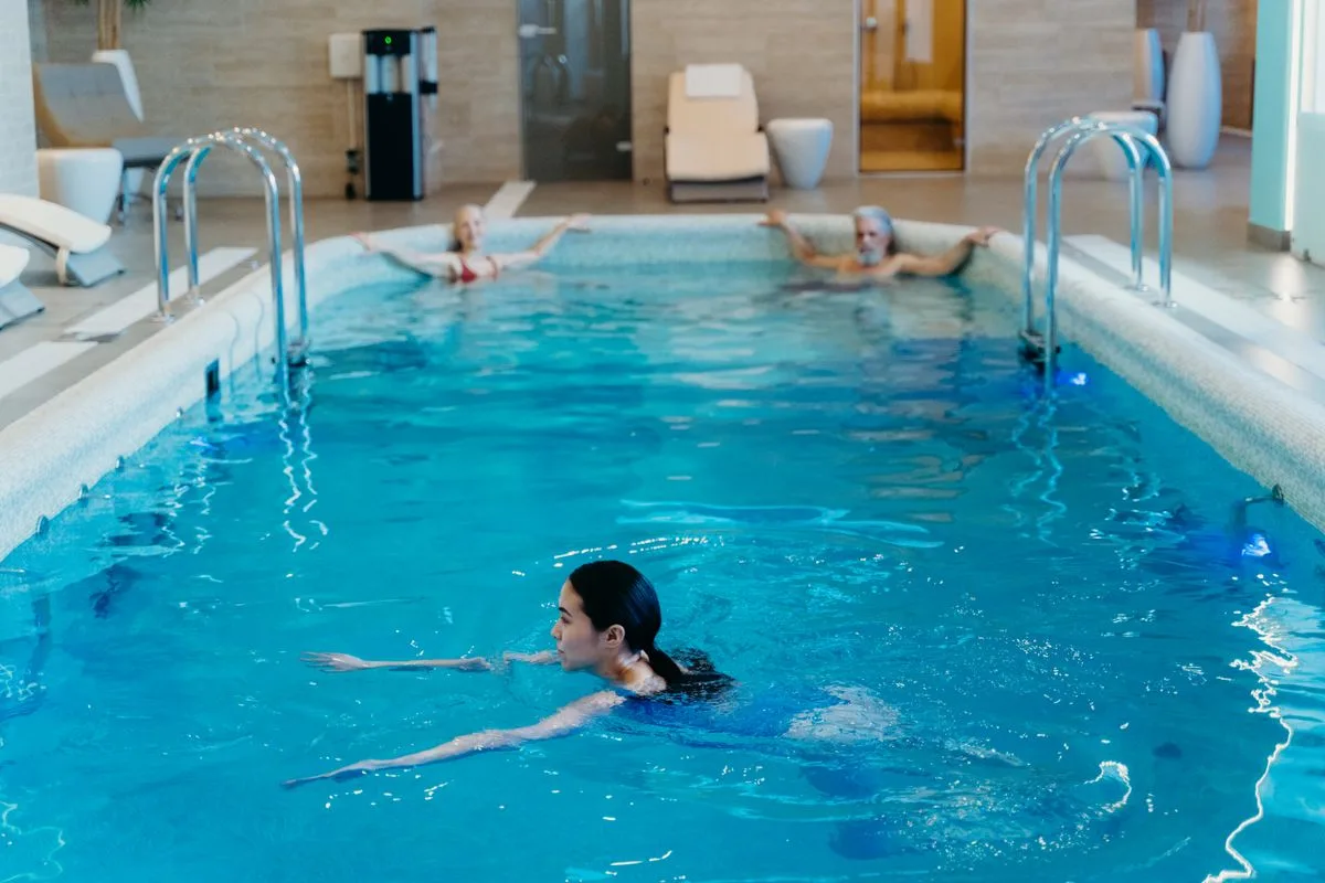 Adults relaxing in an indoor pool at a wellness club -- cool pool for contrast therapy near Valletta