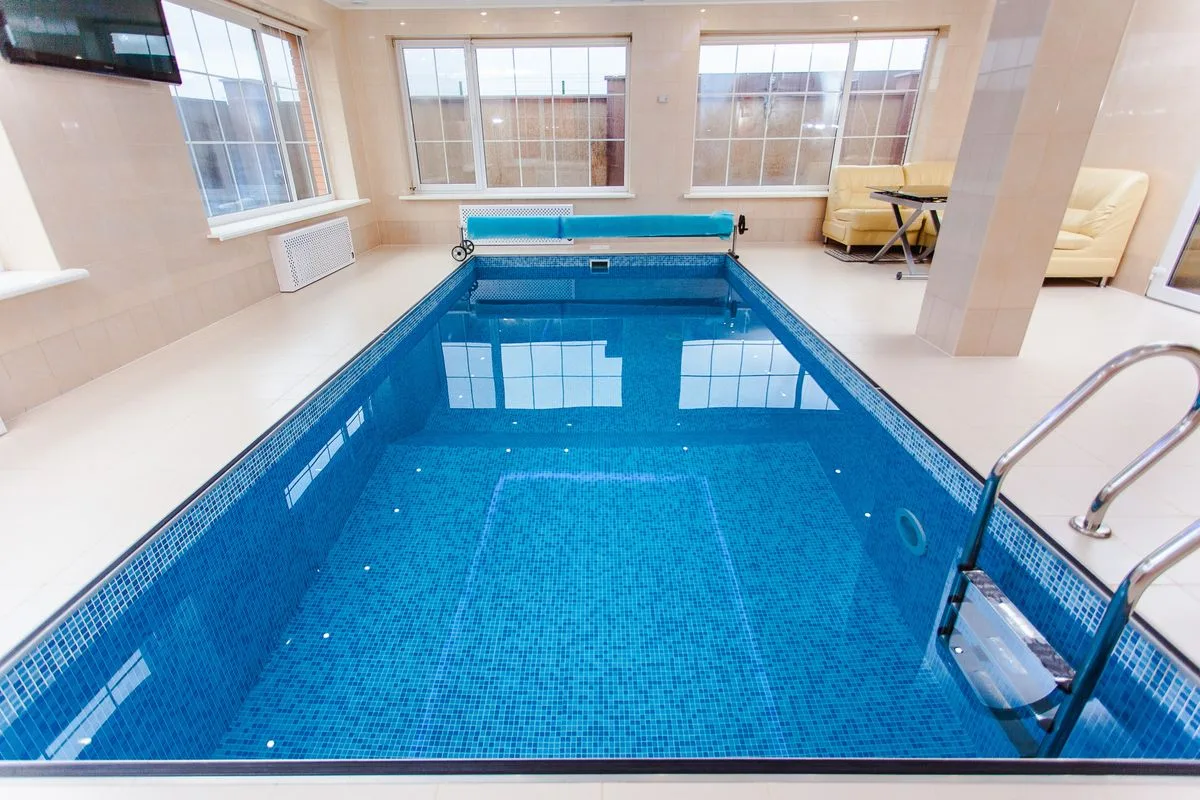 Bright indoor swimming pool with luxury seating — wellness club Malta recovery suite