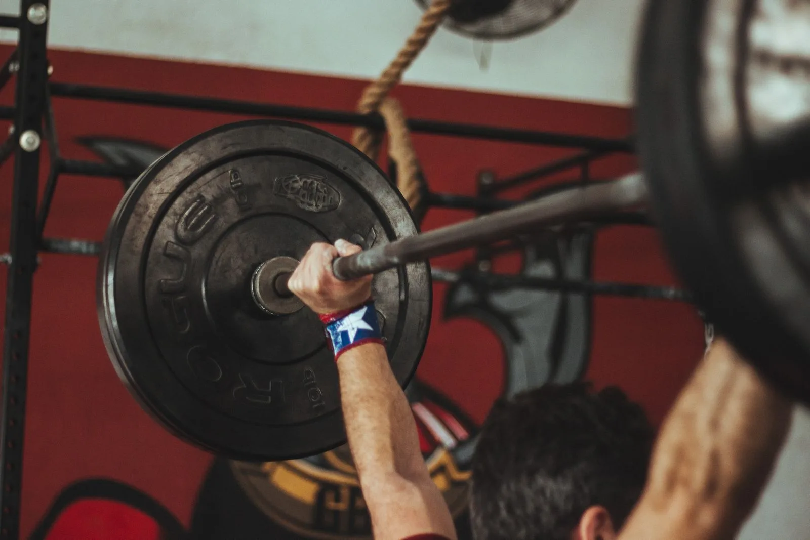 Person training with a barbell in a quiet gym at their own pace